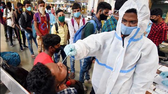 Maharashtra, March 19 (ANI): A healthcare worker takes a swab sample of a passenger for the COVID-19 test at Chhatrapati Shivaji Maharaj Terminus, in Mumbai on Friday. (ANI Photo) (ANI)