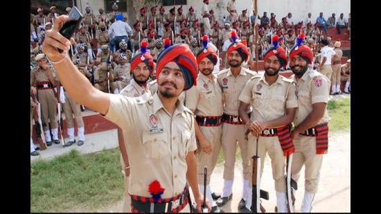 Punjab Police personnel taking a selfie after a marchpast in Amritsar. Apart from 3,100 domain experts to combat specialised crimes, 10,000 police officials will be recruited, of which 33% will be women, at the level of sub inspector and constables. (Sameer Sehgal/HT file photo)