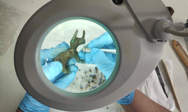 An archaeologist works on a 2,500-year-old bronze bull idol that was unearthed at the archaeological site of Olympia, Greece. (via REUTERS)