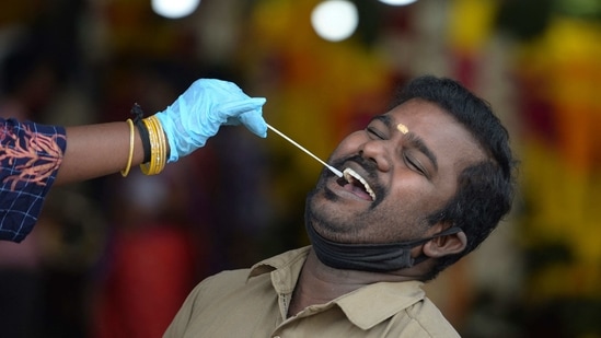 A health worker collects a swab sample from a man to test for coronavirus infection, at a market in Chennai, on March 19. According to the ICMR, 23,35,65,119 samples have been tested up to March 20 with 11,33,602 samples being tested on that day.(Arun Sankar / AFP)