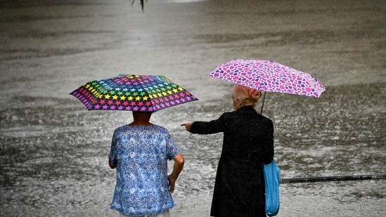 Residents look at the overflowing Nepean river in Penrith suburb on March 21. The Australian government has purchased 50 million doses of the AstraZeneca vaccine to be manufactured locally.(Saeed Khan / AFP)