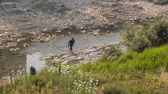 A man believed to be a Myanmar citizen crosses over to India through the Tiau river which bifurcates India and Myanmar. (AP) A man believed to be a Myanmar citizen crosses over to India through the Tiau river which bifurcates India and Myanmar. (AP)