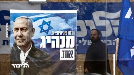 A man walks past a Likud party campaign poster for Prime Minister Benjamin Netanyahu in the city of Sderot, Israel.(AP)