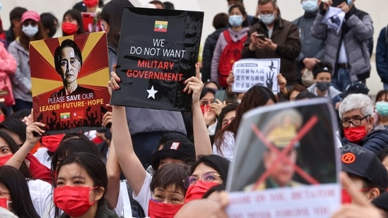 People hold placards as they gather to denounce the Myanmar military coup.(REUTERS)