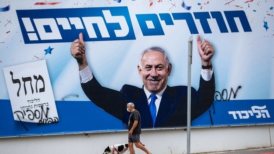 A man walks his dog by an election campaign billboard for the Likud party that shows its leader Prime Minister Benjamin Netanyahu, in Ramat Gan, Israel. (AP) A man walks his dog by an election campaign billboard for the Likud party that shows its leader Prime Minister Benjamin Netanyahu, in Ramat Gan, Israel. (AP)