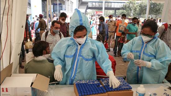 A health worker preserves swab samples collected from travellers for Covid-19 test, at Anand Vihar Bus Terminal, in New Delhi. (Sanchit Khanna/HT PHOTO) A health worker preserves swab samples collected from travellers for Covid-19 test, at Anand Vihar Bus Terminal, in New Delhi. (Sanchit Khanna/HT PHOTO)