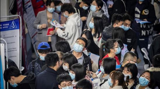 This photo taken on March 21, 2021 shows university graduates attending a career fair in Wuhan, in central China's Hubei province. (Photo by STR / AFP) / China OUT (AFP)