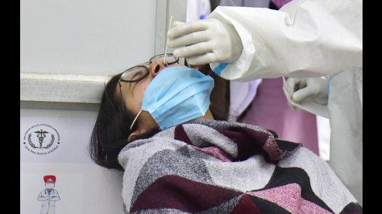 A health worker collects a swab sample for Covid-19 test at a hospital in Amritsar on Monday. (Sameer Sehgal/HT)