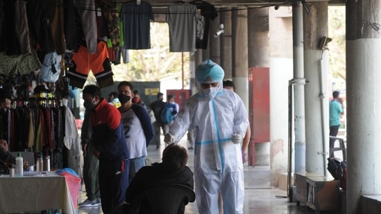 A health worker collects the swab sample of a resident for Covid-19 test at special screening camp at ISBT.