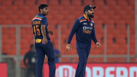 India's Bhuvneshwar Kumar, left, watches as captain Virat Kohli, right, reacts after the dismissal of England's Jos Buttler during the fifth Twenty20 cricket match between India and England at Narendra Modi Stadium in Ahmedabad.(AP)