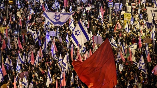 Protesters gather with Israeli and coloured red and pink flags during an anti-government demonstration near the Israeli prime minister's residence in Jerusalem.(AFP) Protesters gather with Israeli and coloured red and pink flags during an anti-government demonstration near the Israeli prime minister's residence in Jerusalem.(AFP)