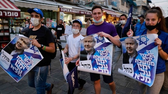 Supporters of Israel's Likud party walk with posters depicting Prime Minister Benjamin Netanyahu during an election campaign tour at Mahane Yehuda market in Jerusalem.(AFP) Supporters of Israel's Likud party walk with posters depicting Prime Minister Benjamin Netanyahu during an election campaign tour at Mahane Yehuda market in Jerusalem.(AFP)