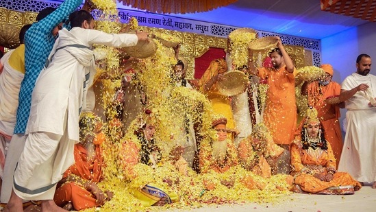Artists dressed as Lord Krishna and saints being showered with flower petals as part of Holi celebrations, at Raman Reti in Mathura district, Wednesday, March 17, 2021. (PTI) Artists dressed as Lord Krishna and saints being showered with flower petals as part of Holi celebrations, at Raman Reti in Mathura district, Wednesday, March 17, 2021. (PTI)