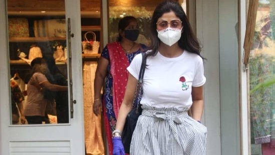 Shilpa Shetty steps out of a store in gloves and mask.