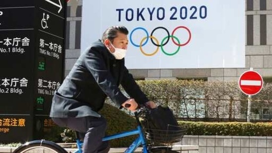A man wearing a face mask cycles past the logo of the Tokyo Olympics, in Tokyo, Wednesday, Feb. 17, 2021. The Olympics are scheduled to open on July 23 but recent polls show about 80% of the Japanese public want the Olympics canceled or postponed. Gov. Tatsuya Maruyama of Shimane prefecture, western Japanese, is talking about canceling the torch relay events in his area for the Tokyo Games, reported on Wednesday. Maruyama is unhappy with COVID-19 prevention measures surrounding the relay. (AP Photo/Koji Sasahara) (AP) A man wearing a face mask cycles past the logo of the Tokyo Olympics, in Tokyo, Wednesday, Feb. 17, 2021. The Olympics are scheduled to open on July 23 but recent polls show about 80% of the Japanese public want the Olympics canceled or postponed. Gov. Tatsuya Maruyama of Shimane prefecture, western Japanese, is talking about canceling the torch relay events in his area for the Tokyo Games, reported on Wednesday. Maruyama is unhappy with COVID-19 prevention measures surrounding the relay. (AP Photo/Koji Sasahara) (AP)