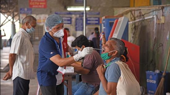 A healthcare worker collects swam samples of passengers for RT-PCR test, at Turbhe railway station in Navi Mumbai on Monday. (Bachchan Kumar/ HT PHOTO) A healthcare worker collects swam samples of passengers for RT-PCR test, at Turbhe railway station in Navi Mumbai on Monday. (Bachchan Kumar/ HT PHOTO)