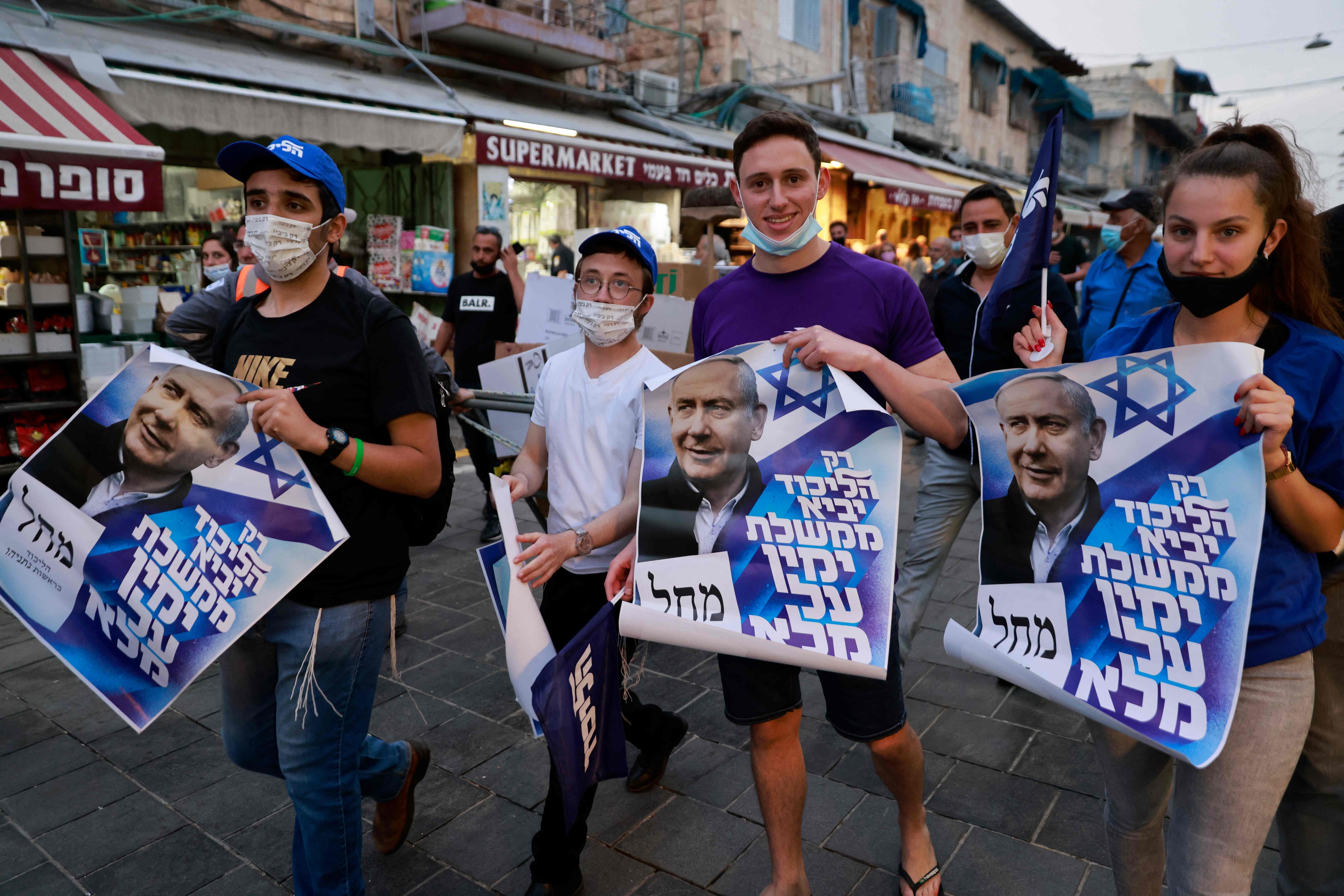 Supporters of Israel's Likud party walk with posters depicting Prime Minister Benjamin Netanyahu during an election campaign tour at Mahane Yehuda market in Jerusalem. (AFP) Supporters of Israel's Likud party walk with posters depicting Prime Minister Benjamin Netanyahu during an election campaign tour at Mahane Yehuda market in Jerusalem. (AFP)