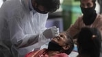 A health worker collects nasal swab of a passenger for Covid-19 test at a long distance train station in Mumbai, on Sunday, March 21. (AP) A health worker collects nasal swab of a passenger for Covid-19 test at a long distance train station in Mumbai, on Sunday, March 21. (AP)