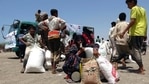 People displaced by conflict receive food aid donated by a Kuwaiti charity organisation in the village of al-Haima in the Khokha district of Yemen's war-ravaged western province of Hodeida, on March 20, 2021. (AFP) People displaced by conflict receive food aid donated by a Kuwaiti charity organisation in the village of al-Haima in the Khokha district of Yemen's war-ravaged western province of Hodeida, on March 20, 2021. (AFP)