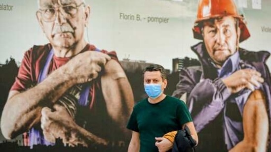 A man walks by large posters advertising the Covid-19 vaccination campaign after getting his injection at a vaccination center that offers both AstraZeneca and Pfizer vaccines in Bucharest, Romania, Tuesday, March 23, 2021. (AP) A man walks by large posters advertising the Covid-19 vaccination campaign after getting his injection at a vaccination center that offers both AstraZeneca and Pfizer vaccines in Bucharest, Romania, Tuesday, March 23, 2021. (AP)