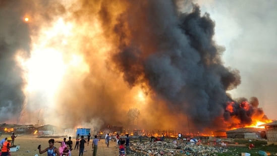 Smoke billows at the site of the fire in Cox's Bazar on March 22. More than a thousand Red Cross staff and volunteers worked with fire services to extinguish the blaze, spread over four sections of the camp containing roughly 124,000 people, around one-tenth of the estimated 1 million Rohingya refugees in the area, Sanjeev Kafley, the International Federation of Red Cross and Red Crescent Societies' delegation head in Bangladesh told Reuters.(REUTERS)