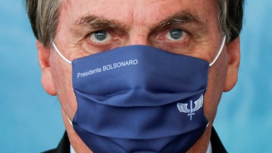 Brazil's President Jair Bolsonaro wears a mask with his name during a ceremony to announce investments for the Aguas Brasileiras Program at the Planalto Palace in Brasilia, Brazil, March 22, 2021. (Reuters)