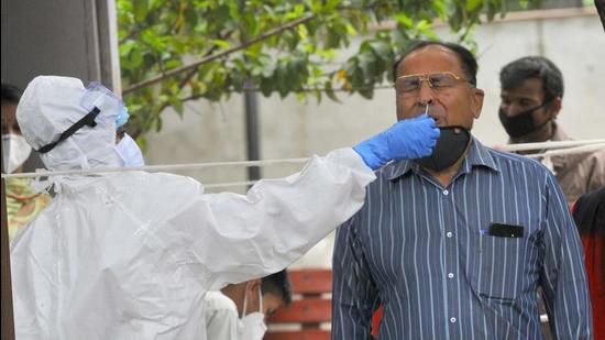 A health worker collects swab samples from people for Covid-19 test at Civil Hospital, Sector 45, Chandigarh on Tuesday. (Keshav Singh/HT) A health worker collects swab samples from people for Covid-19 test at Civil Hospital, Sector 45, Chandigarh on Tuesday. (Keshav Singh/HT)