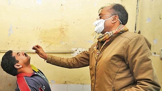 A health worker collects a swab sample to test for Covid-19 at a health centre. (Sunil Ghosh /HT)
