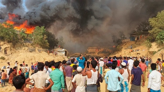 Rohingya refugees watch smoke rising following a fire at the Rohingya refugee camp in Balukhali on March 22. IOM spokeswoman Angela Wells told Reuters that the fire had caused "catastrophic damage", and the health clinic run by the IOM, the camp's largest, was completely destroyed.(AP / PTI)