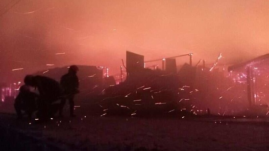 Refugees stand next to burning homes after the fire broke out at Cox's Bazar on March 22. The cause of the fire is still unknown.(REUTERS)