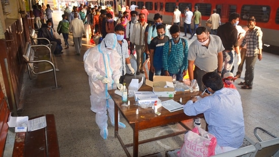 Passengers wait in a queue to give samples for their Covid-19 tests after arriving at a railway station, in Mirzapur.(PTI)