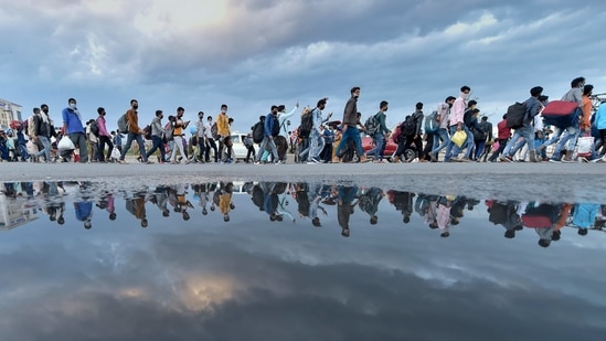 A group of migrant workers walk to their native places amid the nationwide complete lockdown, on the NH24 near Delhi-UP border in New Delhi, Friday, March 27, 2020. (PTI)