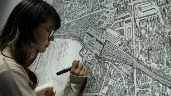 Chinese artist Yang Qian using dots to recreate an aerial view of Wuhan, China, under lockdown at her studio in Wuhan in central China's Hubei province on Sunday, Jan. 24, 2021. Yang, who worked as a volunteer delivering vital supplies to hospitals and residents during the city's pandemic 76-day lockdown, is using her art work to make sure that history is not forgotten. (AP) Chinese artist Yang Qian using dots to recreate an aerial view of Wuhan, China, under lockdown at her studio in Wuhan in central China's Hubei province on Sunday, Jan. 24, 2021. Yang, who worked as a volunteer delivering vital supplies to hospitals and residents during the city's pandemic 76-day lockdown, is using her art work to make sure that history is not forgotten. (AP)