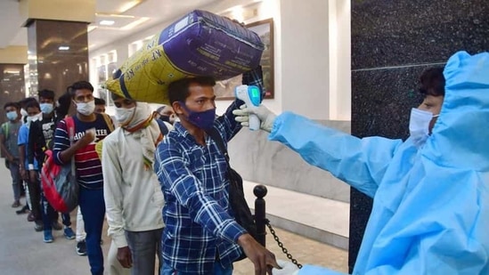 A health worker thermally screens a passenger at CSMT Railway Station, as Covid-19 cases spike across Maharashtra. (PTI) A health worker thermally screens a passenger at CSMT Railway Station, as Covid-19 cases spike across Maharashtra. (PTI)