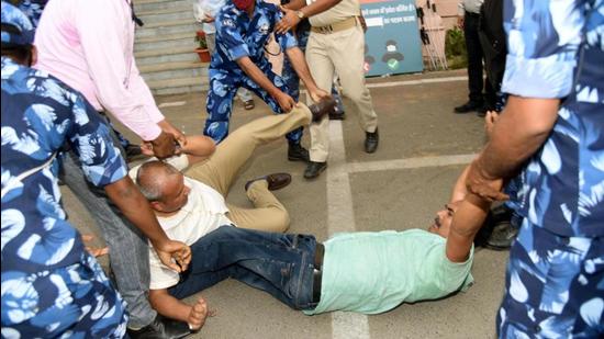 Security personnel removing Grand Alliance legislators who were demonstrating outside Bihar Assembly during Budget Session in Patna, Bihar, on Tuesday. (Santosh Kumar/HT Photo)