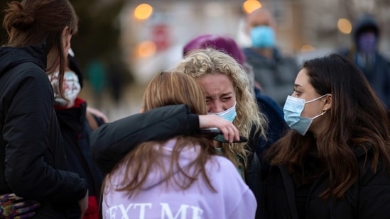 Josie Elowsky (C) cries and hugs her friend, Nirbisha Shetsha, at the site of a mass shooting at King Soopers grocery store in Boulder, Colorado, US. (Reuters)