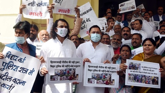 Rashtriya Janata Dal leader Tejashwi Yadav and Tej Pratap Yadav along with the grand alliance legislators hold placards as they stage a protest outside State Assembly House during the budget session, in Patna on Tuesday. (ANI)