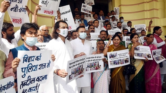 Rashtriya Janata Dal leader Tejashwi Yadav and Tej Pratap Yadav along with the grand alliance legislators hold placards as they stage a protest outside State Assembly House during the budget session, in Patna on Tuesday. (ANI Photo)