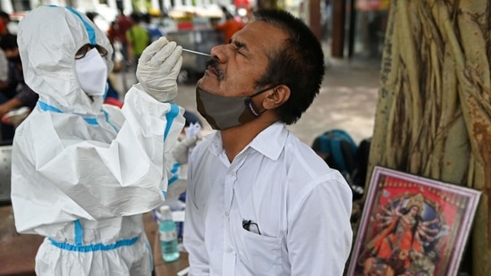 A health worker wearing protective gear collects a swab sample from a man for the Covid-19 coronavirus rapid antigen test (RAT) in Delhi. (AFP)