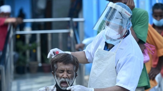 A health worker collects swab sample from a person for Covid-19 test, near Kashmere Gate in New Delhi (PTI)