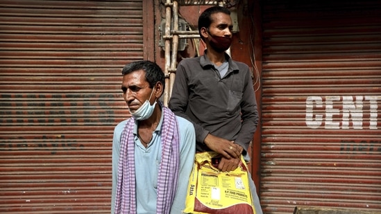 Migrant labourers Nirbhay Yadav, 50, (L), and his son Lovelesh Yadav wait to get employed for the day in New Delhi on March 18. Yadav and his son were part of the biggest migrations in India's modern history. Millions who left the big cities for the countryside, without work because of the lockdown.(Manish Swarup/AP)