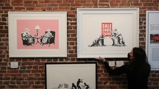 An art handler shows to reporters works by street artist Banksy, as preparations take place for the exhibition "Banksy, (REUTERS)