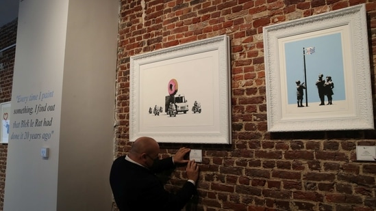 An art handler shows to reporters works by street artist Banksy, as preparations take place for the exhibition "Banksy, (REUTERS)