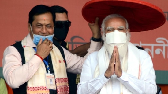 Prime Minister Narendra Modi being felicitated with a traditional Assamese Jaapi by Assam Chief Minister Sarbananda Sonowal during an election rally in Tinsukia on Saturday. (ANI Photo)