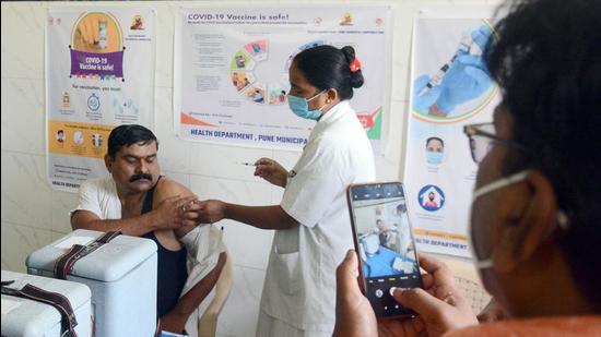A health worker gets his picture clicked, as he gets vaccinated at Rajiv Gandhi hospital in Pune. (Shankar Narayan/HT PHOTO) A health worker gets his picture clicked, as he gets vaccinated at Rajiv Gandhi hospital in Pune. (Shankar Narayan/HT PHOTO)