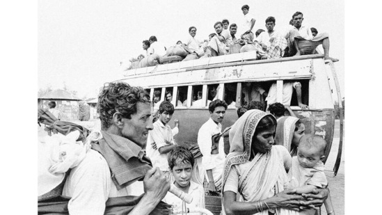 A bus fully laden with refugees prepares to leave as more of them wait for transport in a suburb of Dacca, on April 11, 1971.(Michel Laurent / AP)