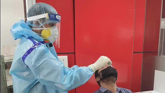 File photo: Health department workers taking sample of Covid-19. (HT photo)