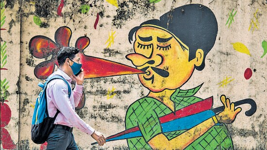 A man passes by a wall graffiti, raising awareness about the need to stop spitting in public, amid the pandemic, at Bandra on Thursday. (Pratik Chorge/HT Photo)