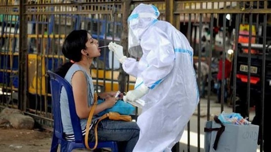 A health worker wearing a PPE kit collects a sample from a woman for the Covid-19 Rapid Antigen Test in Bengaluru. (PTI) A health worker wearing a PPE kit collects a sample from a woman for the Covid-19 Rapid Antigen Test in Bengaluru. (PTI)