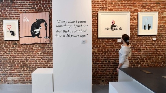 A woman looks at screenprints entitled (from L) "love rat", "the crooner", "the donuts strawberry" and "very little helps" by British artist Banksy during a press viewing of the exhibition "Banksy. (AFP)